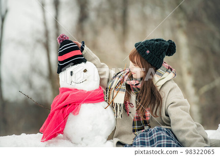 A woman making a snowman and playing A woman making a snowman and playing 98322065