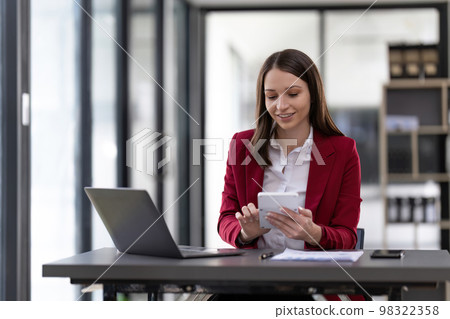 businesswoman using a calculator to check company finances and earnings and budget. Business woman calculating monthly expenses, managing budget, papers, loan documents, invoices 98322358