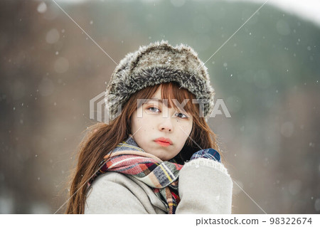 A woman happily watching the snow fall A woman happily watching the snow fall 98322674