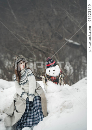 一個女人堆雪人玩得開心 98323149