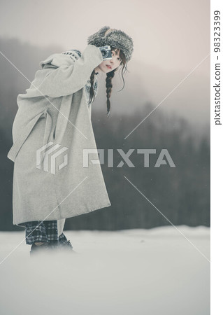 一個拿著相機在雪山中擺姿勢的女人 一個拿著相機在雪山中擺姿勢的女人 98323399