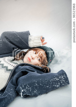 一個女人躺在雪地裡,看起來很開心 一個女人躺在雪地裡,看起來很開心 98323968