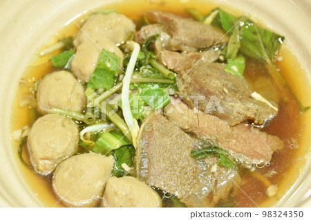 boiled braised beef and meatball in black herb soup on bowl boiled braised beef and meatball in black herb soup on bowl 98324350