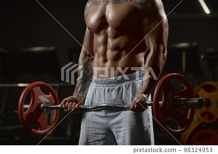 Cropped image of muscular body of sportive man training shirtless in gym indoors. Lifting barbell exercise. Relief body shape. Concept of sport, workout, strength 98324953