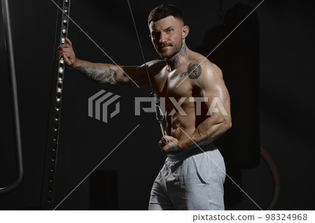 Portrait of young muscular man posing shirtless in gym indoors. Relief, strong, fit body shape. Concept of sport, workout, strength Portrait of young muscular man posing shirtless in gym indoors. Relief, strong, fit body shape. Concept of sport, workout, strength 98324968