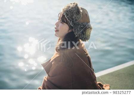 A woman looking happy on the quay under the blue sky 98325277