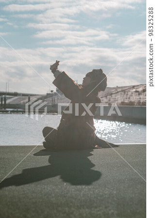 一個女人在藍天下的碼頭上看起來很開心 98325288