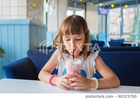 A girl in a cafe, drinking a milkshake. Healthy food 98325700