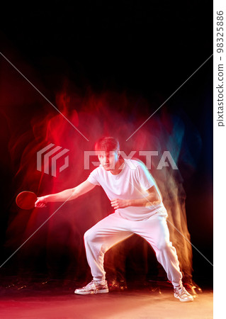 young man playing table tennis in mixed neon light young man playing table tennis in mixed neon light 98325886