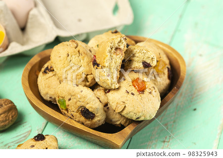 Homemade oatmeal cookies with candied fruit in a heart-shaped plate Homemade oatmeal cookies with candied fruit in a heart-shaped plate 98325943