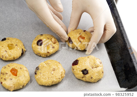 Oatmeal cookies with candied fruits on a baking sheet 98325952