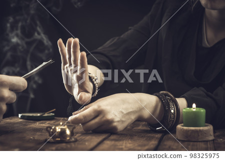 A fortune teller or oracle refuses to take money from a client. Psychic readings and clairvoyance concept A fortune teller or oracle refuses to take money from a client. Psychic readings and clairvoyance concept 98325975
