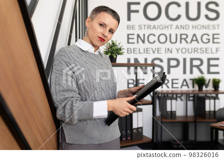 Business woman insurance agent leather folder for documents on office background Business woman insurance agent leather folder for documents on office background 98326016