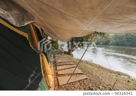 Inside of large comfortable camping tent on campground in the tropical forest by riverside on vacation 98326341