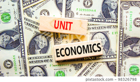 Unit economics symbol. Concept words Unit economics on wooden blocks. Beautiful background from dollar bills. Business and unit economics concept. Copy space. 98326798
