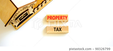 Property tax symbol. Concept words Property tax on wooden blocks. Beautiful white table white background. House model from wooden parts. Business and property tax concept. Copy space. 98326799