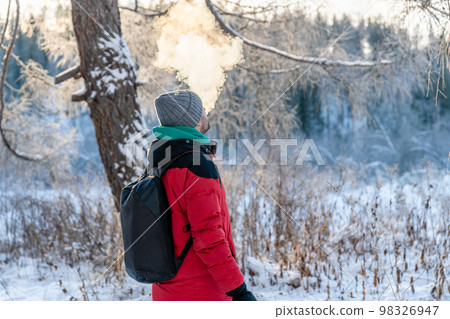 a man in the winter in the cold exhales a cloud of steam, smoke a man in the winter in the cold exhales a cloud of steam, smoke 98326947