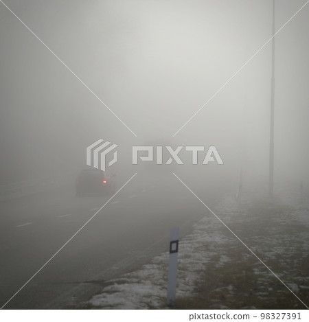 Cars in the fog. Traffic on the road in winter in bad weather. Dangers of driving cars. 98327391