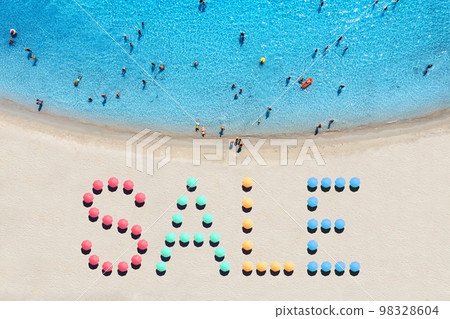Creative text made from umbrellas on sandy beach and blue sea 98328604