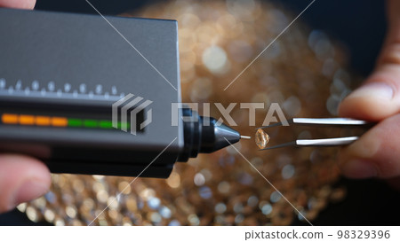 Specialist evaluates quality and cost of diamonds using special device. 98329396