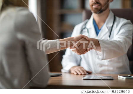 Medical Services Concept. Doctor And Female Patient Handshaking During Meeting In Clinic 98329643
