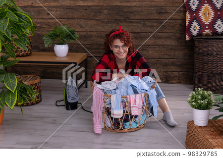 A young woman in a good mood before starting to iron clothes. 98329785