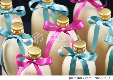 Homemade eggnog in bottles with blue and pink bows on dark background 98330623
