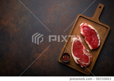 Two raw meat beef rib eye marbled steaks on wooden cutting board 98330663