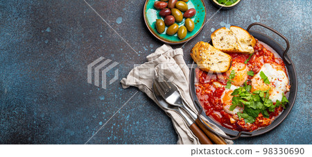Middle Eastern and Maghrebi healthy dish Shakshouka made of eggs and tomato sauce served in pan Middle Eastern and Maghrebi healthy dish Shakshouka made of eggs and tomato sauce served in pan 98330690