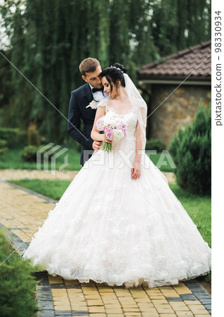 Romantic wedding moment, couple of newlyweds smiling portrait, bride and groom hugging 98330934