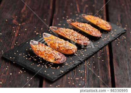 Baked mussels with cheese sesame seeds in shells - asian food Baked mussels with cheese sesame seeds in shells - asian food 98330995