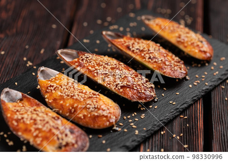 Baked mussels with cheese sesame seeds in shells - asian food Baked mussels with cheese sesame seeds in shells - asian food 98330996