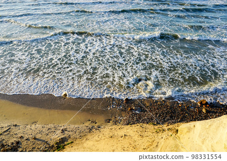 Beautiful view of rocky Baltic Sea coast, sand dune and waves with white foam tops in sunset light Beautiful view of rocky Baltic Sea coast, sand dune and waves with white foam tops in sunset light 98331554