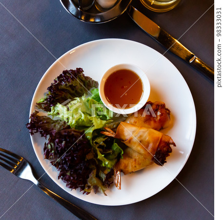 Fried spring rolls with vegetables and shrimps with sauce and salad Fried spring rolls with vegetables and shrimps with sauce and salad 98333031