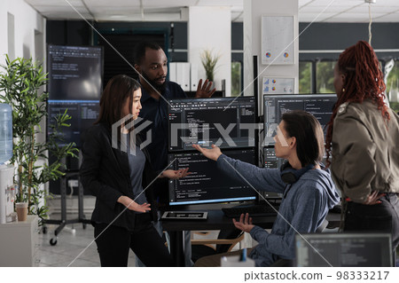 Multi ethnic web developers writing script while talking about develop cloud computing server. IT engineers having unexpected server error and no access to database, hacking attack. Multi ethnic web developers writing script while talking about develop cloud computing server. IT engineers having unexpected server error and no access to database, hacking attack. 98333217