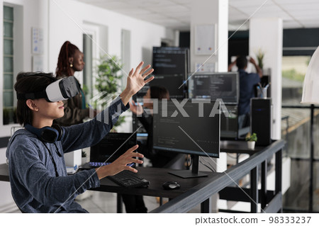 Asian programmer working with virtual reality glasses in it big data office, using vr headset to develop security program. Web developer coding html script with database on computer Asian programmer working with virtual reality glasses in it big data office, using vr headset to develop security program. Web developer coding html script with database on computer 98333237