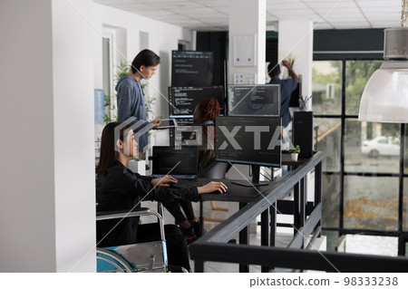 Asian disabled software programmer writing html code in agency big data room, using security system. Engineer with physical disability programming user interface artificial intelligence office. Asian disabled software programmer writing html code in agency big data room, using security system. Engineer with physical disability programming user interface artificial intelligence office. 98333238
