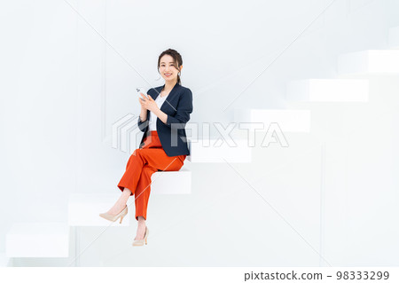 坐在樓梯上看著智能手機的年輕女商人 98333299