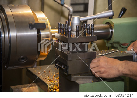 The machine operator working with lathe machine. 98334214