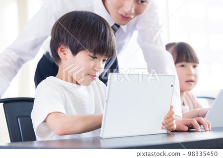 Children and teacher learning on tablet Children and teacher learning on tablet 98335450