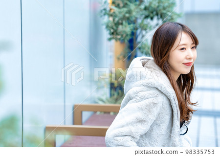 度假郊遊時坐在長椅上的年輕女子 98335753