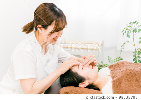 接受眉毛和鼻樑按摩的亞洲女性和治療師 接受眉毛和鼻樑按摩的亞洲女性和治療師 98335793