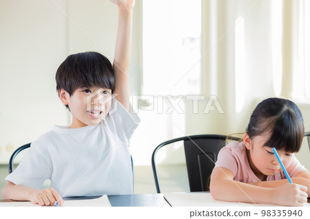 Child raising hand to answer in class Child raising hand to answer in class 98335940