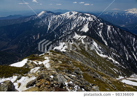 The ridgeline to Mt. Chogatake with remaining snow seen from the summit of Mt. Jonen in the Northern Alps The ridgeline to Mt. Chogatake with remaining snow seen from the summit of Mt. Jonen in the Northern Alps 98336609