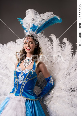 Smiling woman in vintage blue dress with feathers Smiling woman in vintage blue dress with feathers 98337240