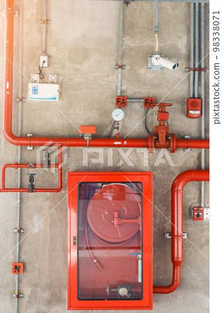 Fire extinguisher and water pump system on the wall, powerful emergency equipment for apartment and hotel 98338071