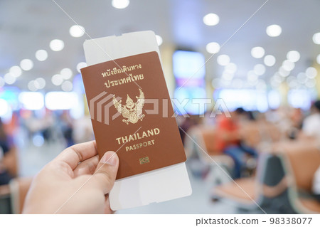 Hand holding Thailand passport and boarding pass ticket in International airport. Travel, vacation and transportation concepts Hand holding Thailand passport and boarding pass ticket in International airport. Travel, vacation and transportation concepts 98338077