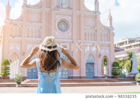 Woman Traveler with blue dress visiting in Da Nang city. Tourist sightseeing the Da Nang Cathedral church. Landmark and popular for tourist attraction. Vietnam and Southeast Asia travel concept Woman Traveler with blue dress visiting in Da Nang city. Tourist sightseeing the Da Nang Cathedral church. Landmark and popular for tourist attraction. Vietnam and Southeast Asia travel concept 98338235