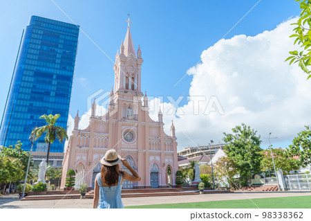Woman Traveler with blue dress visiting in Da Nang city. Tourist sightseeing the Da Nang Cathedral church. Landmark and popular for tourist attraction. Vietnam and Southeast Asia travel concept 98338362