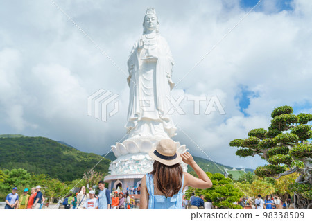 Woman traveler visiting at Linh Ung Pagoda temple or Lady big Buddha. Tourist with blue dress and hat traveling in Da Nang city. Vietnam and Southeast Asia travel concept 98338509